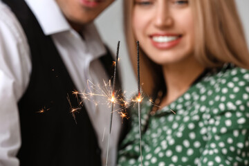 Poster - Happy young couple with Christmas sparklers, closeup