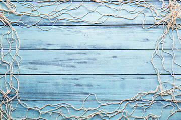 frame made of fish net on color wooden background