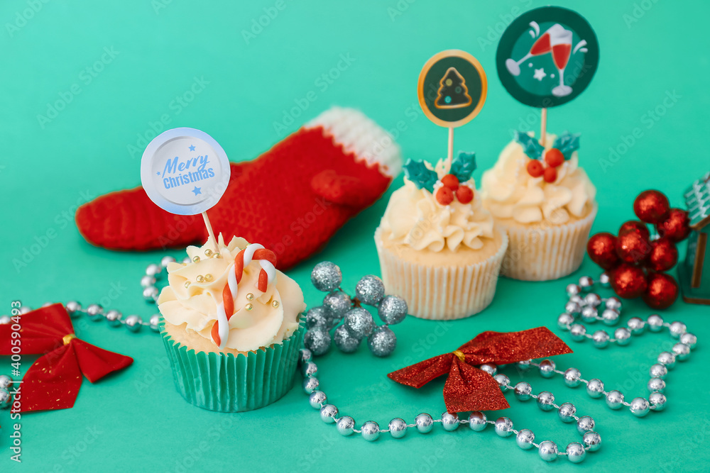 Composition with tasty Christmas cupcakes and decor on color background