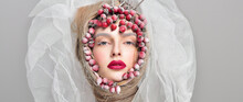 Beautiful Woman Face With Professional Makeup, Frosty Winter Beauty. Close Up Portrait. Surrounded By Red Berries