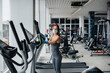 © Andrii - The girl in the mask disinfecting the gym equipment during a pandemic.