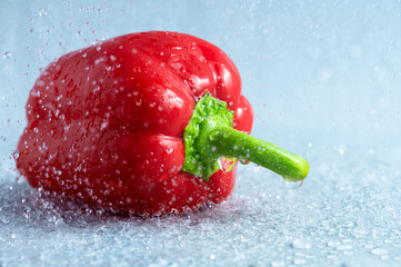 Fresh ripe red bell pepper in a splash of clean water, fresh vegetables from an organic farm.