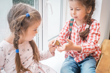 Two little girls holding a beautiful butterfly in their hands