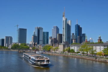 a boat on the river main in the background the skyline of frankfurt on main, in germany