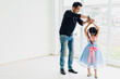 © Nawarit - An Asian father and daughter are dancing, dad teaches daughters to dance in a fun room
