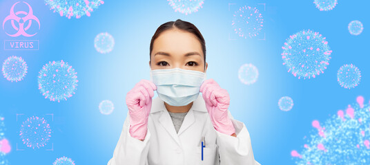 Wall Mural - health, medicine and pandemic concept - young asian female doctor or scientist wearing face medical mask and gloves for protection from virus disease over coronavirus molecules on blue background