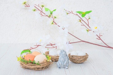 Wall Mural - Easter holiday greeting card. Three nests with eggs, rabit and twig with white flowers