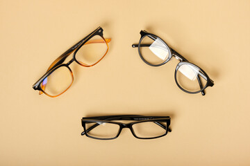 several pairs of glasses on a beige background