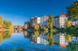 Park at the shore of Lake Lietzen with buildings reflecting in the water in Berlin, Germany