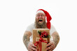 © Taras Grebinets - Isolated portrait on a white background of an overweigh laughing man with tattooed arms in Santa hat presenting Christmas gifts.