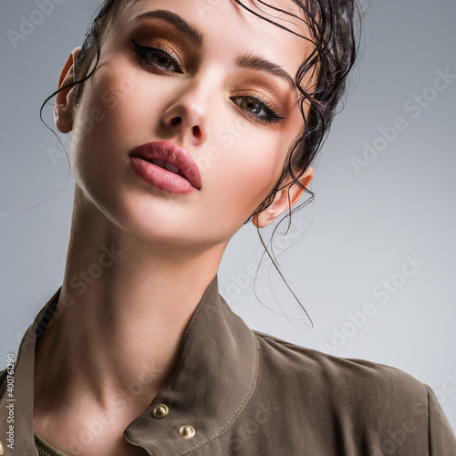 Fotografering Closeup portrait of a beautiful young fashion woman with glamour makeup posing at studio