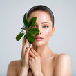 © Valua Vitaly - Beautiful woman with green leave near face and body.  Closeup girl's face with green leave. Skin care beauty treatments concept.