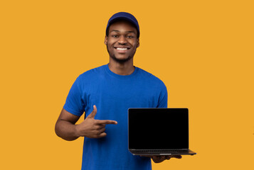 Wall Mural - Black delivery man holding laptop with blank screen for mockup