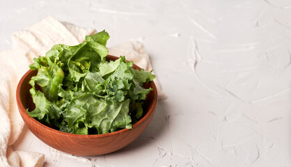 Wall Mural - Healthy food concept, fresh organic kale in wooden bowl on the white table background with copy space