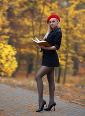 Wall Mural - Girl with perfect legs and red beret posing outdoor in the of autumn park.