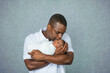 © Ursula Page - An attractive African-American new father is holding his newborn son and giving him a kiss with a white-gray background.