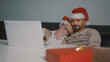 © CameraCraft - Young caucasian gay couple with Santa Claus hats watching movies on the laptop on the Christmas Eve. High quality photo