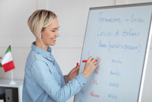 Teaching Foreign Languages Online. Cheerful Female Teacher Giving Italian Class, Writing Down Basic Rules On Blackboard