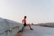 © VITTA GALLERY/Westend61 - Woman exercising while leaning on wall against clear sky