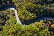 © Cameron Davidson/Westend61 - Aerial view of asphalt road winding through alpine forest in autumn