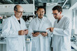 © Mareen Fischinger/Westend61 - Team of scientist using digital tablet while standing at laboratory
