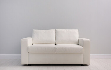 Wall Mural - Comfortable white sofa near light wall indoors, space for text. Simple interior