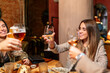 © Oscar Carrascosa Martinez/Westend61 - Friends toasting drink while sitting by table at restaurant
