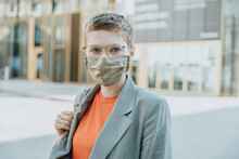 Woman Wearing Protective Face Mask Standing On Street In City During Sunny Day