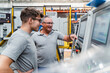 © Daniel Ingold/Westend61 - Male engineers brainstorming while testing machine at factory