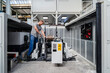 © Daniel Ingold/Westend61 - Expertise tightening machine bolts while standing at factory