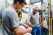 © Daniel Ingold/Westend61 - Male coworkers brainstorming while standing against machinery in industry
