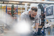 © Daniel Ingold/Westend61 - Mid adult male technician examining machine at illuminated industrial factory