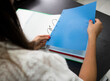 © MORNINGVIEW AGENCY/Westend61 - Businesswoman attaching paper in file while sitting on desk at office