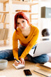 © Giorgio Fochesato/Westend61 - Young woman with laptop on lap writing in note pad while studying at home