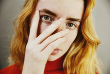 Blond Teenage Girl Covering Face With Hand