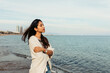 © VALENTINA BARRETO STUDIO/Westend61 - Carefree woman with arms crossed looking at sea against sky