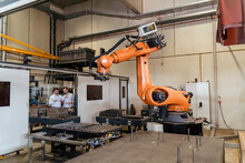 Business People Standing By Automatic Robot Arm Machine At Factory