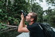 © Daniel Sierralta/Westend61 - Male backpacker photographing nature from canoe at Napo River, Ecuador