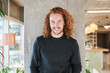 © Jo Kirchherr/Westend61 - Smiling redhead man standing against column at home