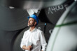 © KNSY/Westend61 - Thoughtful smiling male owner holding digital tablet looking up while standing in factory