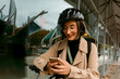 © VALENTINA BARRETO STUDIO/Westend61 - Smiling woman with electric push scooter using mobile phone while standing against glass wall