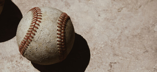 Old baseball used in game on blurred texture background for sports banner with copy space.