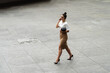 © Mikel Taboada/Westend61 - Young businesswoman talking through mobile phone while walking on footpath in city