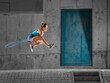 © Stefan Schurr/Westend61 - Young woman jumping over skipping rope against concrete wall under bridge