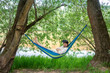 © Vasily Pindyurin/Westend61 - Man with 3d glasses relaxing on hammock at riverside
