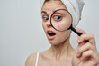 © SHOTPRIME STUDIO - pretty woman with towel on head skin care magnifier near face