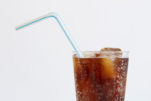 Studio Shot Of Cold Drink With Ice Cubes And Plastic Straw On White Background