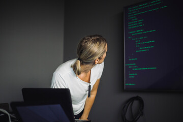 Female computer professional looking at projection screen in creative office