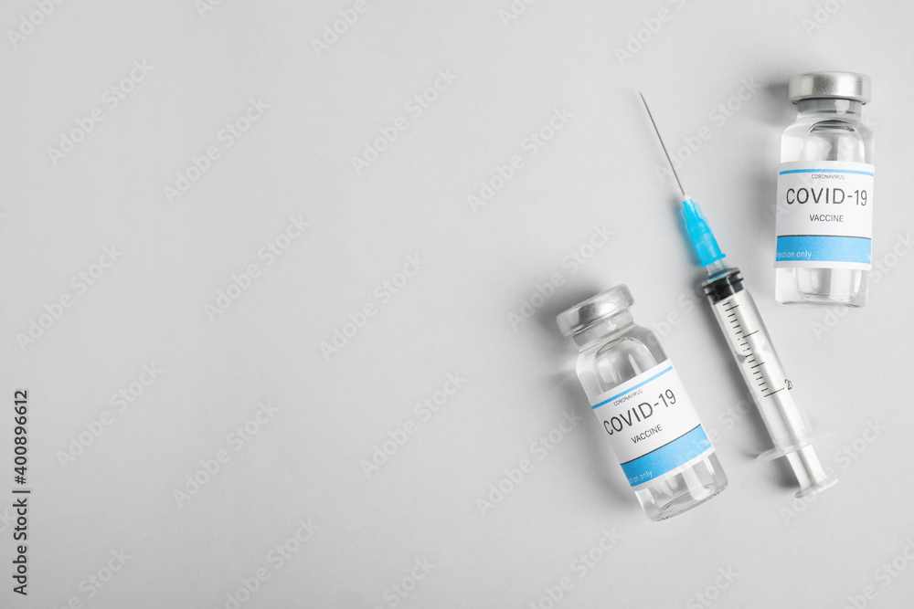 Vials with coronavirus vaccine and syringe on light background, flat ...