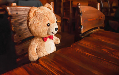 teddy bear sitting at the table. famili cafe. russian style. restaurant. Wooden furniturecopy space. brown.